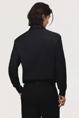 Camisa de corte entallado con cuello inglés, tapeta clásica y canesú en la espalda. Presenta mangas largas con puños ajustables mediante botones y bajo levemente redondeado. Confeccionada en tela con tratamiento de fácil planchado.