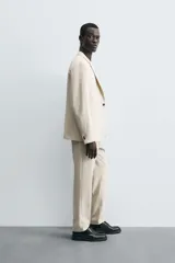 Pantalón de corte recto confeccionado en tejido con lana, color beige. Presenta bolsillos frontales, bolsillos traseros de vivo y cierre frontal con cremallera y botón.
