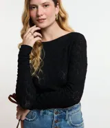 Blusa de manga larga color negro con cuello barco, confeccionada en tejido de punto con textura calada de diseño geométrico.