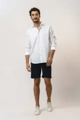 Camisa de vestir de manga larga en color blanco, con cuello clásico y cierre frontal de botones.