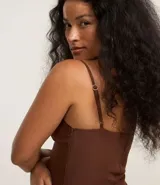 Vestido corto marrón de poliéster y elastano, corte sastrero, con escote recto, breteles finos, recorte en el busto y aberturas laterales.