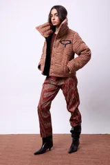 Pantalón de corte recto con largo al tobillo, confeccionado con una estampa geométrica sublimada en tonos marrón y rojo. Presenta tiro medio y un calce cómodo.