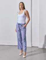 Pantalón de lino estampado a rayas verticales azules y blancas, marca DASH. Tiene pretina ancha elastizada con lazo ajustable.