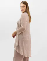 Conjunto de tres piezas compuesto por una musculosa recta, un cardigan liviano de frente abierto con mangas 3/4 y un pantalón de seda fría. La musculosa y el cardigan están confeccionados en tejido plisado con hilos metalizados tornasolados. Incluye collar removible y forro interno a tono.