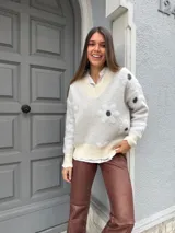 Buzo color blanco con cuello en V, mangas largas y estampado de lunares negros.