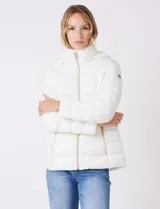 Campera puffer Michael Kors de color blanco, con diseño acolchado, cierre frontal metálico, bolsillos laterales con cierre y capucha desmontable. Incluye bolsa autoportante para guardado.