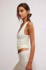 Musculosa de tejido texturado sin costuras, color negro, con escote redondo pronunciado y tiras anchas. Presenta un diseño ajustado y corto al cuerpo.