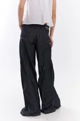 Jean de tiro medio estilo wide leg, confeccionado en denim azul oscuro, con recortes frontales y pespuntes a contratono en color ocre.