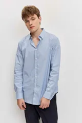 Camisa celeste de manga larga con cierre frontal de botones y cuello clásico.