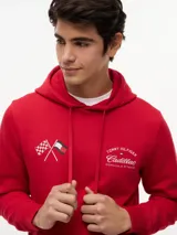 Buzo con capucha de Tommy Hilfiger en colaboración con Cadillac Formula 1 Team. Confeccionado en algodón, presenta un diseño de color rojo con bolsillo tipo canguro, puños y bajo acanalados. Incluye bordados en el pecho con banderas cruzadas y el logo de la colaboración.