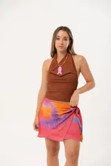 Minifalda multicolor con estampado abstracto en tonos naranja, rosa y violeta. Diseño cruzado con lazo lateral.