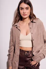 Camisa color marrón claro de gamuza vegana, corte oversize, con cuello clásico, cierre frontal con botones y mangas largas.