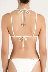 Top de bikini triangular color crema con doble bretel y detalles de esferas metálicas doradas en el centro y en los tirantes.