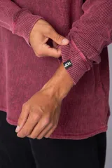 Buzo de corte oversize confeccionado en tela waffle de algodón con proceso de teñido acid wash. Presenta cuello redondo con detalle de costura en X y mangas largas con puños acanalados.