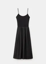 Vestido midi color negro con cuerpo ajustado de escote redondo y tirantes finos, combinado con una falda larga fruncida de tejido ligero y fluido.