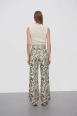 Pantalón recto con estampado floral en tonos verde y beige.