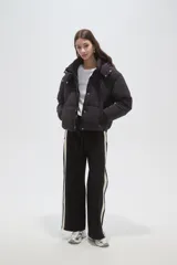 Campera puffer negra con capucha, manga larga, cierre frontal y cuello alto.