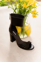 Sandalia de cuero vacuno color negro, con tiras finas en la parte delantera y pulsera ancha en el tobillo con cierre trasero. Taco ancho de 9 cm.