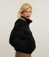 Campera puffer de terciopelo cotelé color negro, con cuello alto y cierre frontal por botones. Diseño acolchado con textura acanalada.