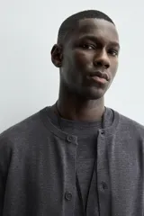 Cárdigan de punto con lana, de corte regular fit, cuello redondo y manga larga. Presenta cierre frontal con botones y acabados en rib en puños y bajo.