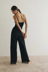 Pantalón de corte holgado en popelina de algodón, color negro, con cintura elástica y cordón de ajuste. Presenta piernas rectas, franjas de encaje en los laterales y ribete de encaje en los bajos.