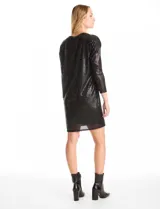 Vestido corto de lentejuelas color negro, con silueta recta y relajada, cuello redondo y mangas largas con sisa caída. La prenda cuenta con un forro interior completo.