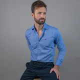 Camisa de vestir azul celeste de manga larga, con cuello clásico y botones frontales. Presenta un pequeño logo bordado en el pecho.