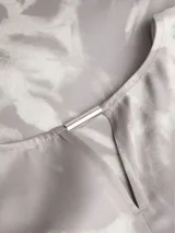 Blusa de satén gris con estampado abstracto en blanco, escote en V y mangas cortas.
