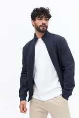 Campera tipo bomber de algodón y poliéster color azul marino, con cuello mao y cierre frontal. Presenta una textura tejida en zigzag en el cuerpo.