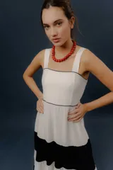 Vestido largo de diseño tricolor con bloques horizontales en blanco y azul marino, tirantes anchos y falda amplia en capas.