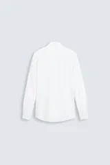 Camisa de manga larga color celeste claro, corte slim fit, con cuello italiano abierto y cierre frontal de botonadura.