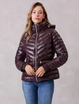 Campera puffer de acabado satinado en color marrón oscuro. Presenta un diseño capitoneado con líneas en V, cierre frontal metálico, capucha fija y puños internos de tejido elastizado con abertura para el pulgar. Incluye bolsillos laterales con cierre invisible y logo metálico en la manga.