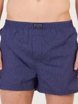 Bóxer de algodón blanco con estampado de flores pequeñas color celeste, con cintura elástica y logo de la marca en el centro.