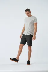 Bermuda tipo chino de gabardina, con bolsillos laterales y traseros, cierre de cremallera y botón, y pasacintos en la cintura. Presenta un diseño clásico con logo bordado.