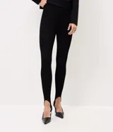 Pantalón legging negro de punto acanalado con estribo en el talón y cintura alta, de corte ajustado al cuerpo.