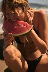 Conjunto de bikini a rayas horizontales blancas y azul marino, con corpiño triangular con tirantes finos y bombacha con tiras laterales ajustables.