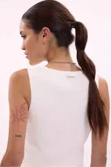 Chaleco tejido de punto color blanco, sin mangas, con escote en V y cierre frontal con botones dorados.