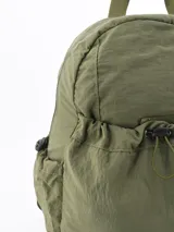 Mochila de tela técnica color verde militar, con compartimento principal y bolsillo frontal con cierre de cordón ajustable. Cuenta con bolsillos laterales y correas de hombro ajustables.