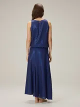Falda larga azul marino de tejido satinado, con detalle de aplique floral en la cintura.