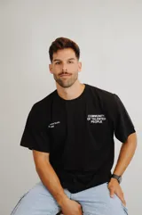 Remera negra de corte holgado con estampa frontal en color blanco que incluye el texto 'COMMUNITY OF TALENTED PEOPLE' y detalles adicionales en el lado derecho.