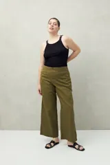 Pantalón de tiro medio con silueta amplia y estructura firme, confeccionado en algodón. Presenta detalle de ojalillos metálicos decorativos en los laterales.