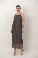 Vestido midi de gasa negro, con solera sin mangas, escote fruncido y detalle de aplique floral en el hombro.