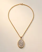 Collar de cadena de eslabones con baño de oro y dije ovalado colgante con relieve de San Benito en tono plateado y borde dorado.