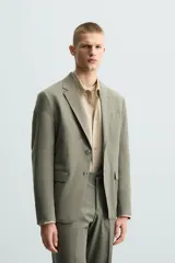 Blazer de corte regular fit confeccionado en tejido con lana, con cuello de solapas de muesca, cierre frontal de un botón, bolsillos de solapa en la cadera y bolsillo de vivo en el pecho.