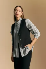 Camisa de manga larga con diseño de rayas verticales en tonos grises y blancos, cuello camisero y cierre frontal con botones.