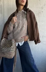 Sweater de punto color beige con bordado de flores blancas en el frente y las mangas, cuello redondo y puños acanalados.