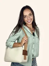 Bolso tipo baguette color crudo con doble correa al hombro de cuero color camel.