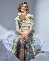 Bufandón de lana merino afieltrada color natural, formado por piezas horizontales unidas que generan una textura continua.