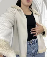 Campera color crudo de pana con cuello, puños y ruedo de corderito. Tiene cierre frontal y corte recto.