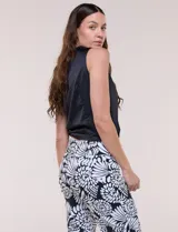 Blusa de satén color negro, de corte fluido, con escote asimétrico y un aro metálico decorativo en el hombro.